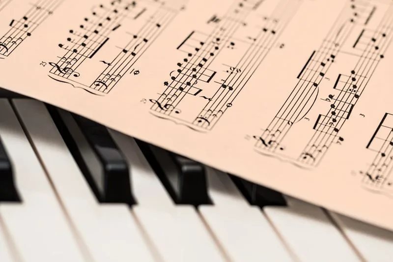 Sheet music resting on piano keys
